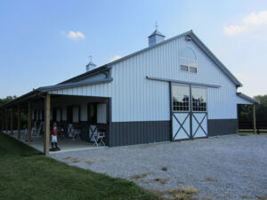 Equestrian post-frame barn at dusk.