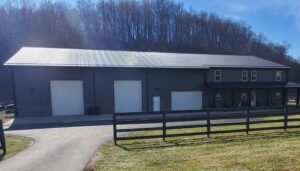 Barndominium built by Classic Buildings with wood fence and large front yard