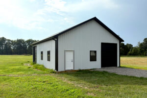 Front view of commercial post frame construction building, door and side garage