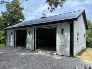 Residential post frame construction garage with white color and gray roof